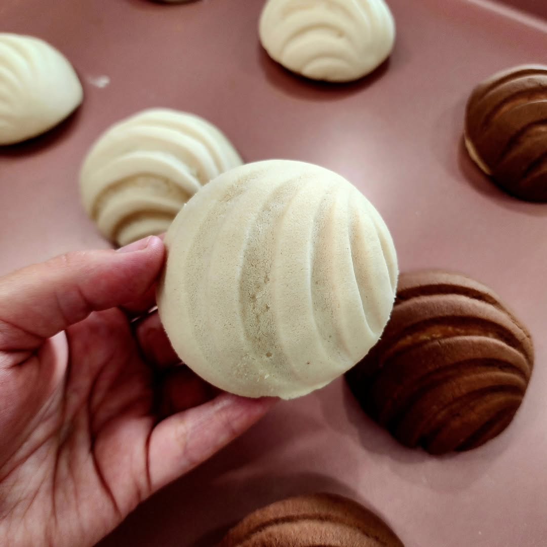 Hand holding a vanilla concha by La Concheria